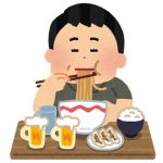 ラーメン・ご飯・餃子を食べながらビールを飲んでいる男性
