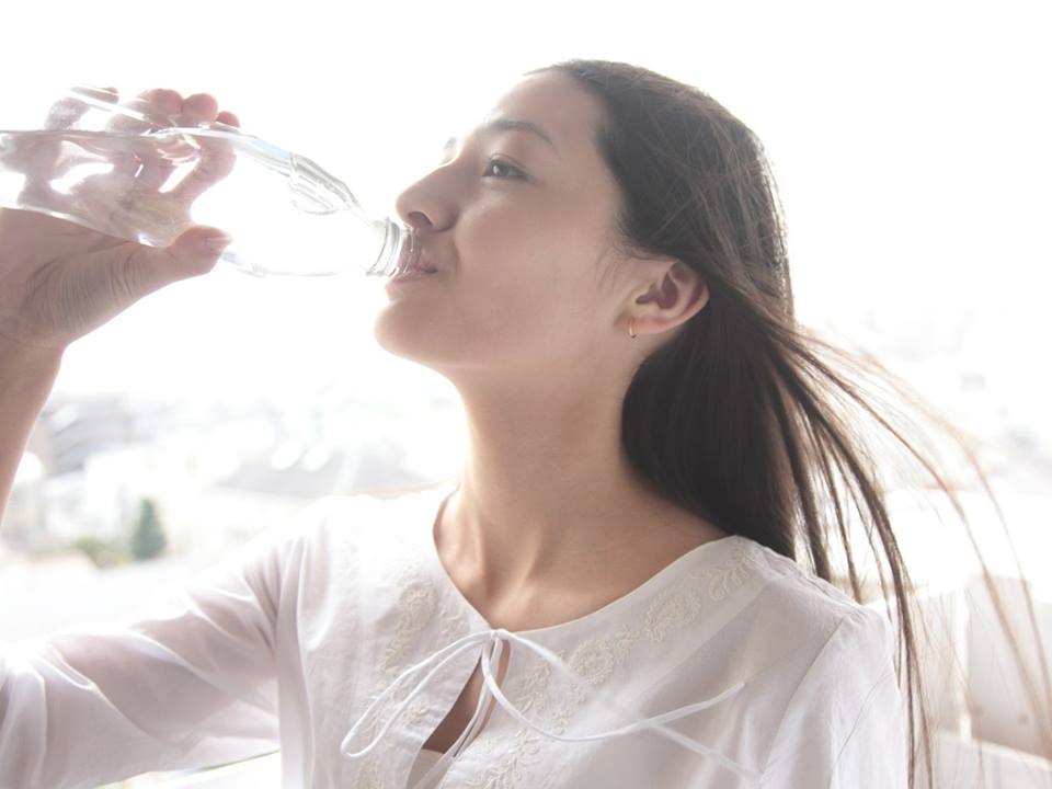 水を飲む若い女性